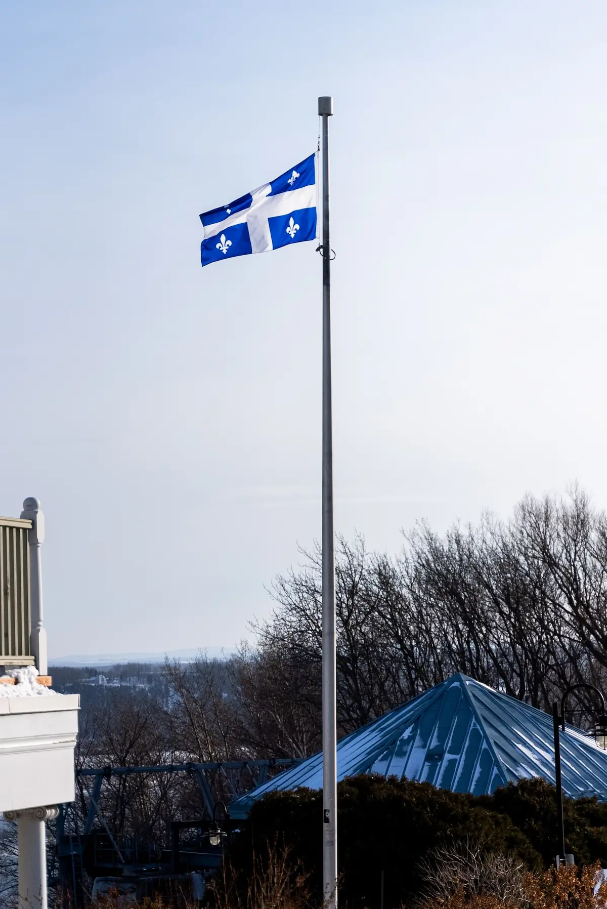 Drapeau du Québec flottant, symbole de l'ancrage local de Service Mécanique MG